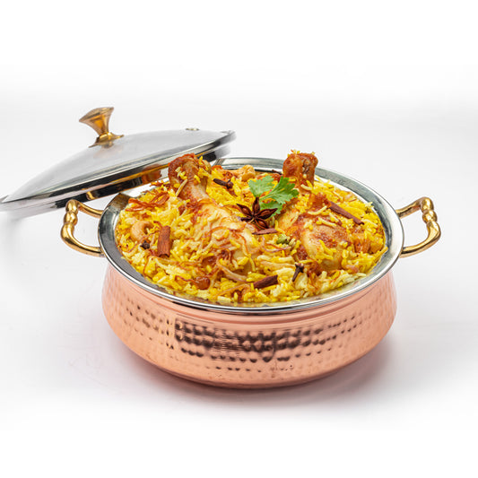 Chicken biriyani served in a copper handi, prepared using Mantra Herbs Biriyani Masala – homemade Kerala-style spice blend.