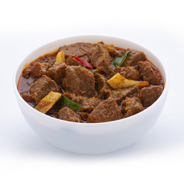 Kerala-style meat curry served in a white bowl, prepared using Mantra Herbs Meat Masala – homemade natural spice blend for rich, authentic flavour.