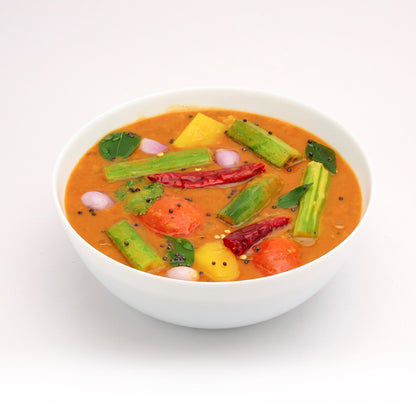 Traditional Kerala sambar served in a white bowl, prepared using Mantra Herbs Sambar Powder – homemade South Indian spice blend.